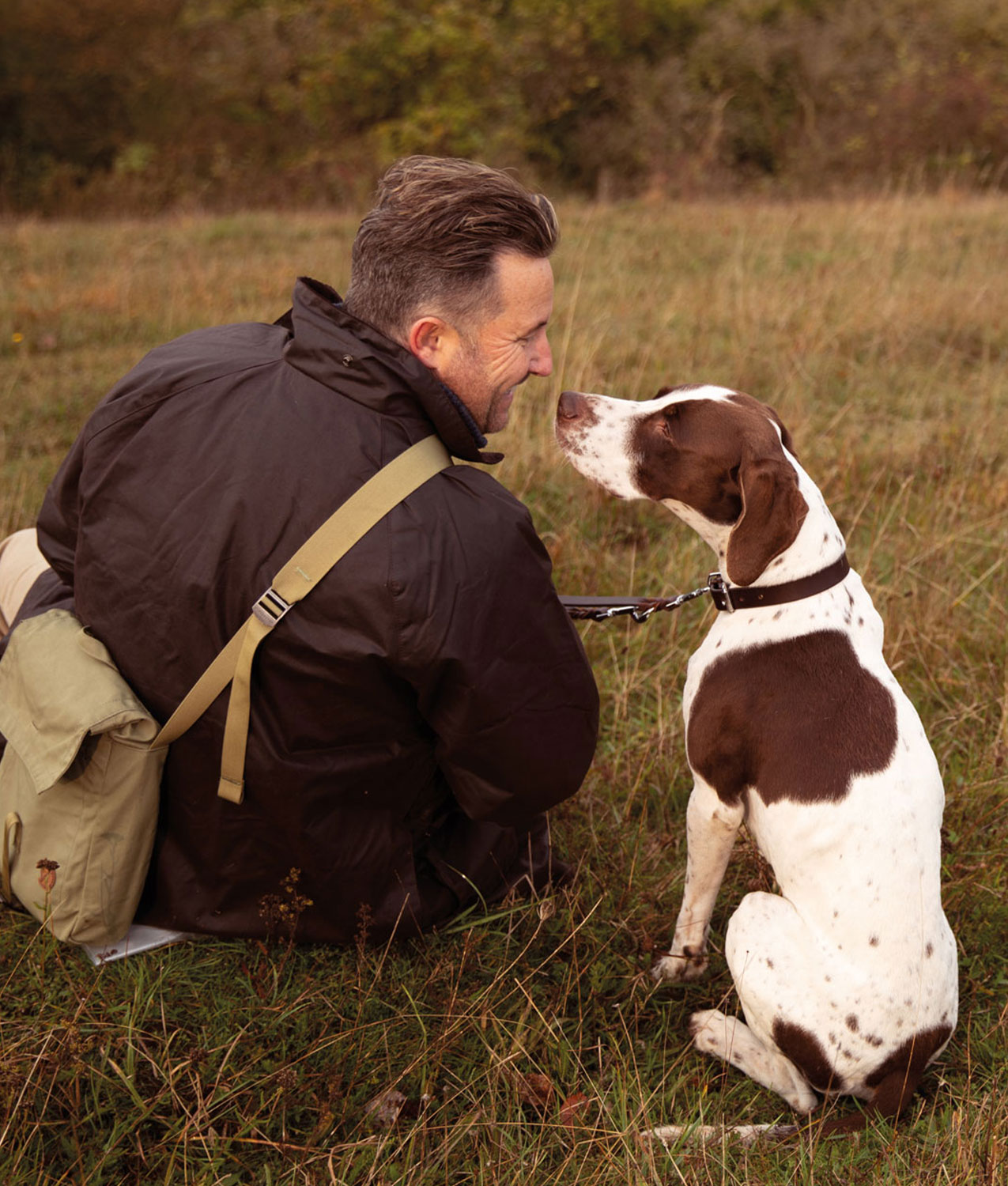 Man sitting in a field with his dog